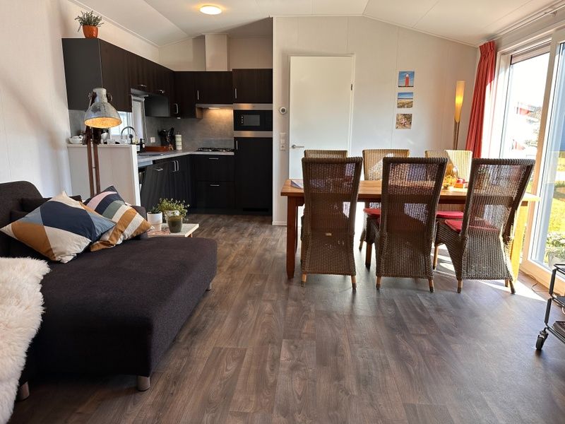 Vacation park de Bremakker - Bosveld 141, Texel, dining area with wooden table and wicker chairs, ideal for family.