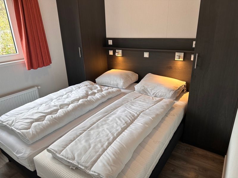 Comfortable bedroom in Holiday Park de Bremakker - Bosveld 141, Texel with double bed and atmospheric lighting.