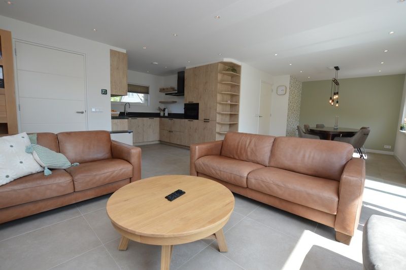 Moderne woonkamer in Tempelierweg - Kogermient 18, De Dennen Texel, met leren banken en open keuken.