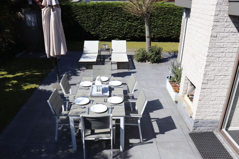 Aussenbereich des Ferienhauses Gortersmient 358 in De Dennen, Texel mit Esstisch und Liegestuehlen.