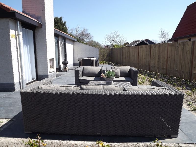 Zonovergoten terras bij Vakantiehuis Gortersmient 320 in De Dennen, Texel, met stijlvolle loungeset voor ultiem relaxen op de Waddeneilanden.