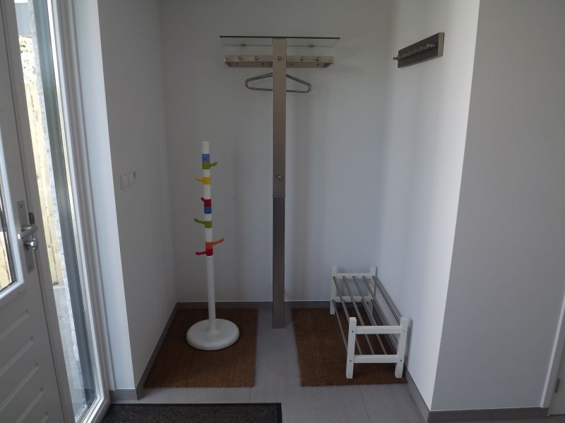 Ingang van Vakantiehuis Gortersmient 320, De Dennen, Texel met praktische kapstok en schoenenrek, ideaal voor een georganiseerde vakantie.