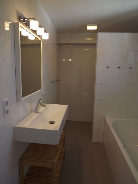 Luxe badkamer in Vakantiehuis Gortersmient 320, Texel met elegant design, ruime wastafel en comfortabele ligbad voor ontspanning.