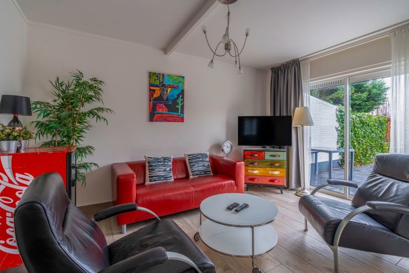 Cozy living room of Bungalowpark 't Luwe Land - Texelfan, De Dennen, Texel. Modern decor with colorful accents.
