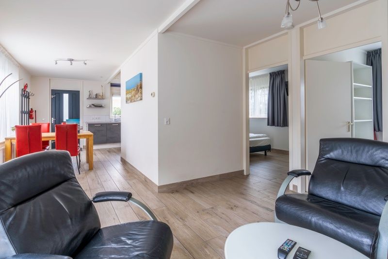 Open living room in Bungalowpark 't Luwe Land - Texelfan, De Dennen, Texel. Spacious layout with access to bedrooms.