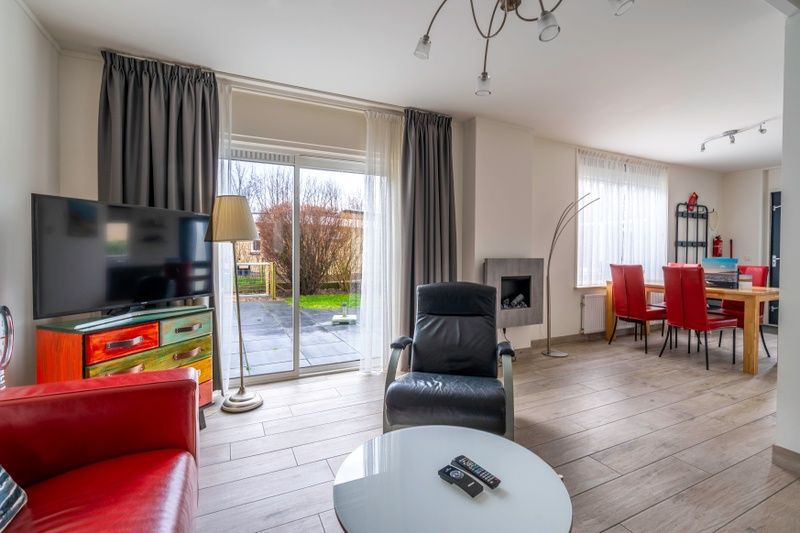 Bright living room of Bungalowpark 't Luwe Land - Texelfan, Texel. Large windows overlooking the garden in De Dennen.