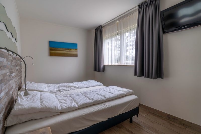 Bedroom in Bungalowpark 't Luwe Land - Texelfan, Texel. Comfortable beds with natural light in De Dennen.