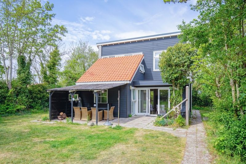 Vakantiehuis Bungalowpark Gortersmient - Blommenzee in De Dennen, Texel met groene omgeving en terras.