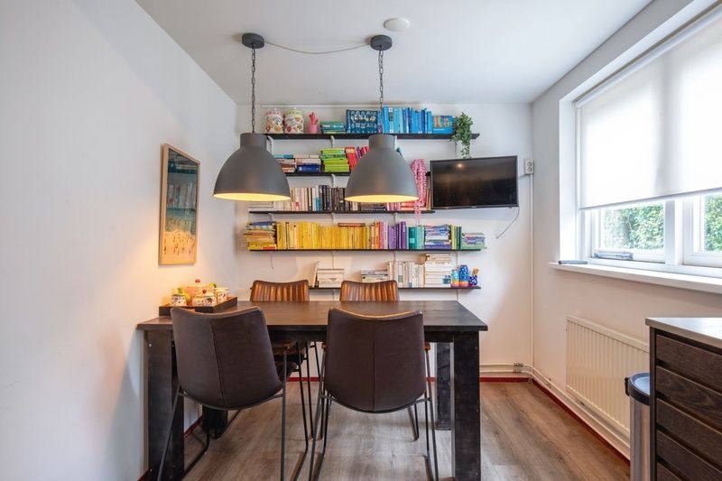 Gezellige leeshoek in Bungalowpark Gortersmient - Blommenzee, De Dennen, Texel met boeken en verlichting.