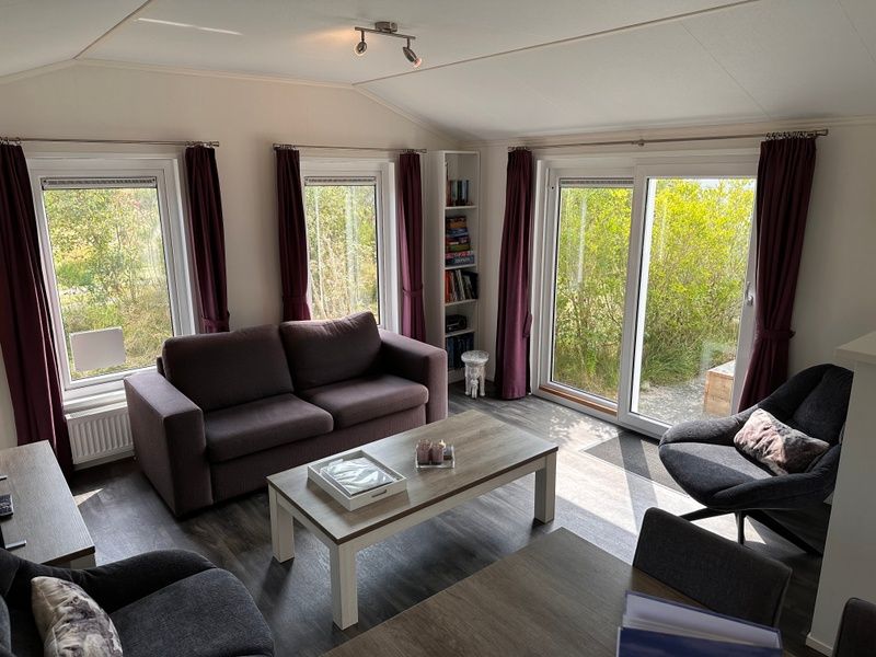 Bright living room with a view of nature at Vakantiepark de Bremakker, Texel.