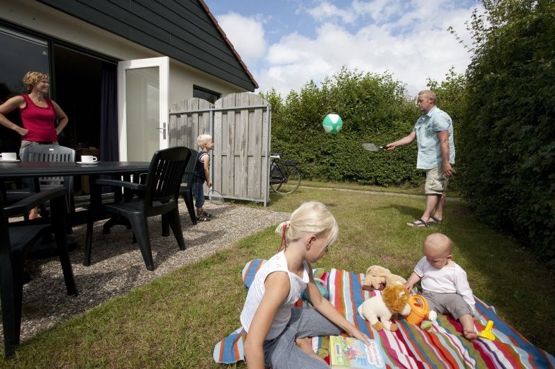 Gezellige tuin bij Type 2 - 6 persoons vakantiehuis in De Dennen, Texel met spelende kinderen.