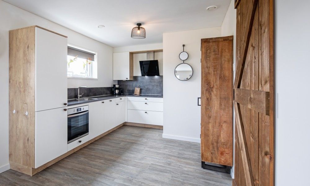 Moderne Kueche in Wulpenweid 10 de Wulp, Ferienhaus De Dennen Texel mit Holzakzenten.