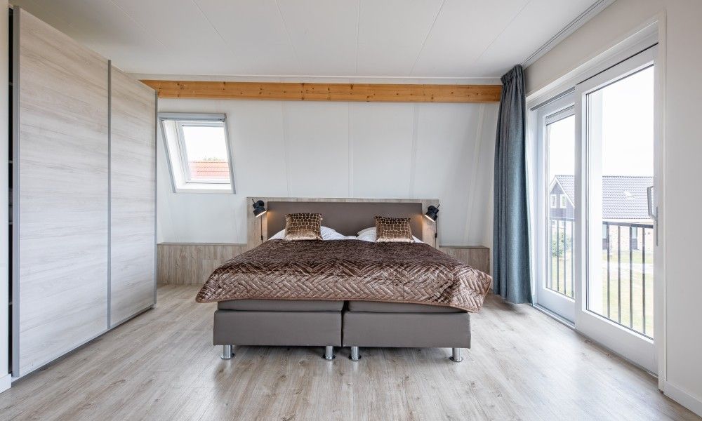 Geraeumiges Schlafzimmer in Wulpenweid 10 de Wulp, Ferienhaus De Dennen Texel mit Balkon und viel Licht.