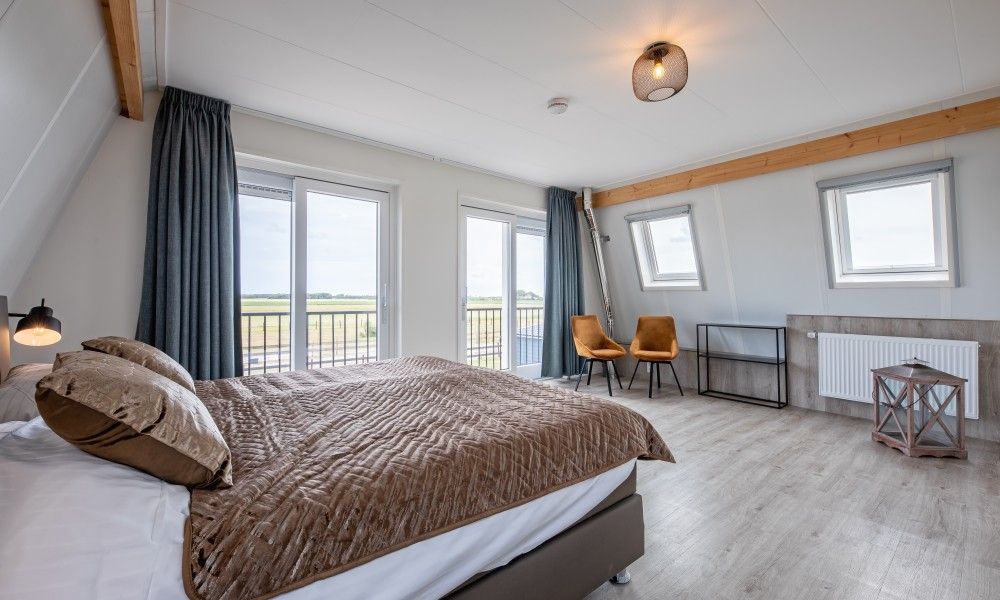 Schlafzimmer mit Aussicht in Wulpenweid 10 de Wulp, Ferienhaus De Dennen Texel mit grossen Fenstern.