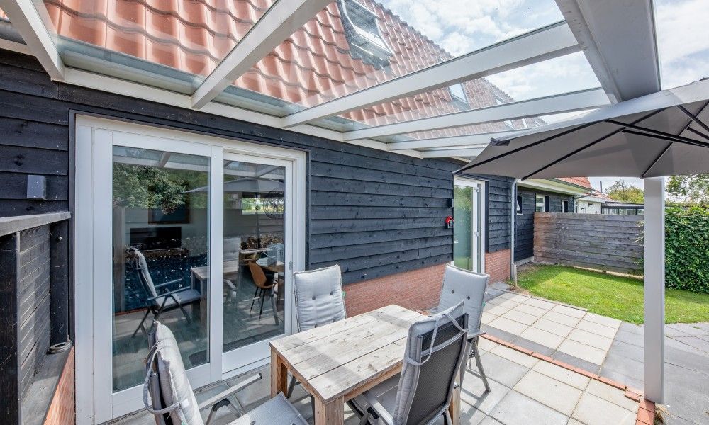 Ueberdachte Terrasse in Wulpenweid 10 de Wulp, Ferienhaus De Dennen Texel mit bequemen Sitzgelegenheiten.