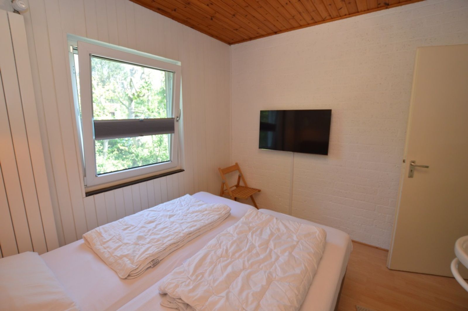 Lichte slaapkamer met TV in vakantiehuis Tempelierweg 10, Texel.