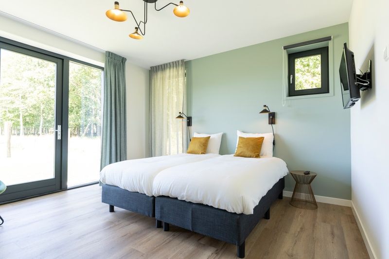 Helles Schlafzimmer im Ferienhaus 1 in De Dennen Texel, mit bequemen Betten und ruhiger Atmosphaere.