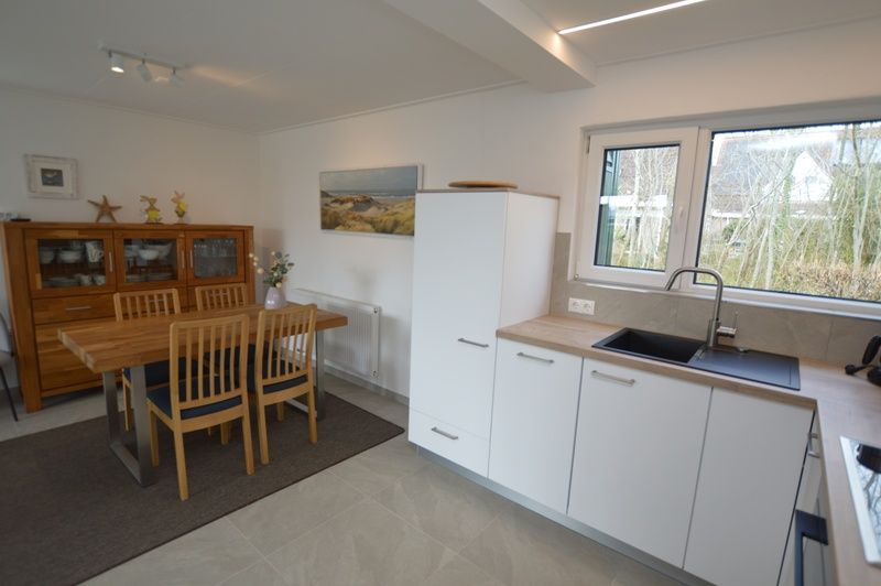 Kitchen and dining area of Tempelierweg 38, vacation home in De Dennen, Texel with lots of light.