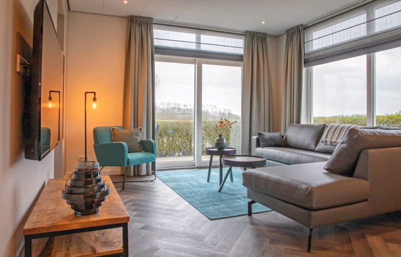 Comfortabele binnenruimte met grote ramen in Appartement Bos en Duin 01, De Dennen, Texel.