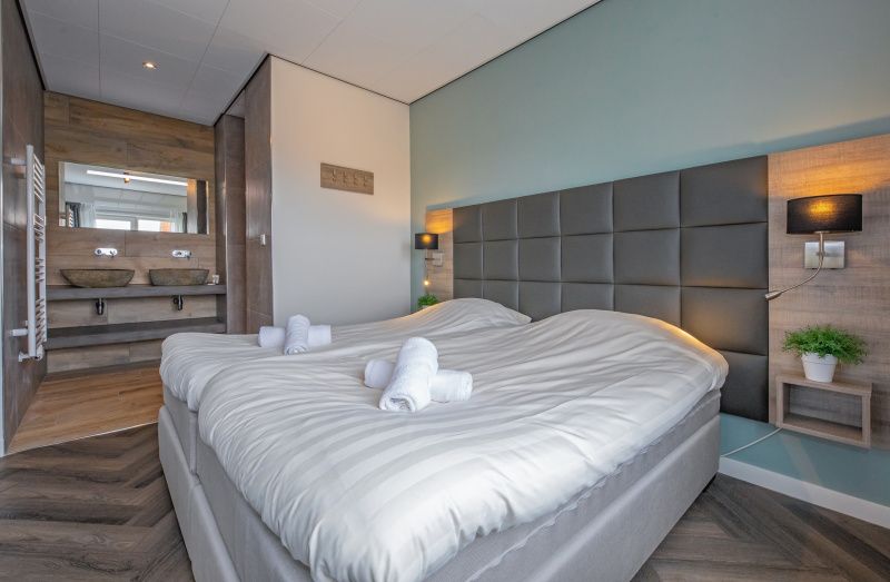 Luxe slaapkamer met ensuite badkamer in Appartement Bos en Duin 01, De Dennen, Texel.