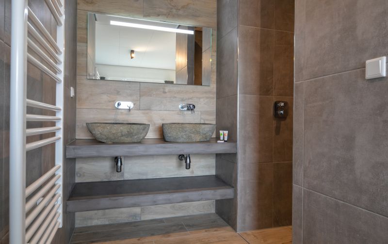Moderne badkamer met dubbele wastafel in Appartement Bos en Duin 01, De Dennen, Texel.