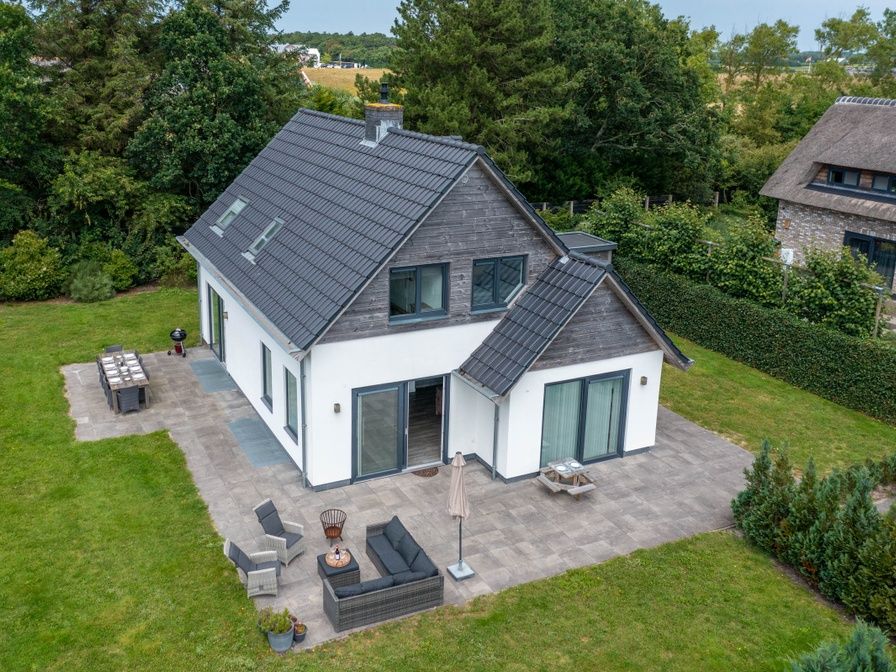 Luftaufnahme von Bungalowpark 't Hoogelandt - Villa 106F, einem geraeumigen Ferienhaus in De Dennen, Texel, umgeben von Gruenanlagen.