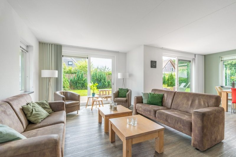 Die Villa 106F im Bungalowpark 't Hoogelandt auf Texel bietet ein helles Wohnzimmer mit Zugang zu Terrasse und Garten.