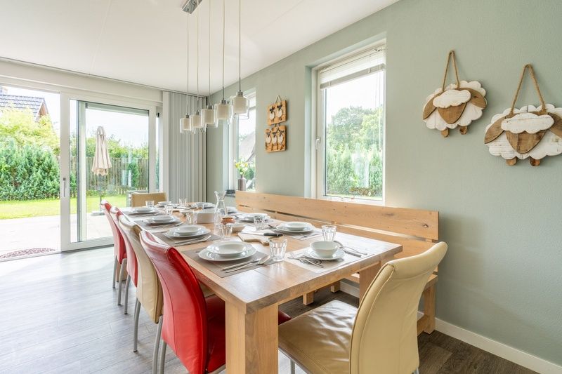 Gemuetliche Essecke im Bungalowpark 't Hoogelandt - Villa 106F, Texel, mit grossem Tisch und Zugang zum Garten.