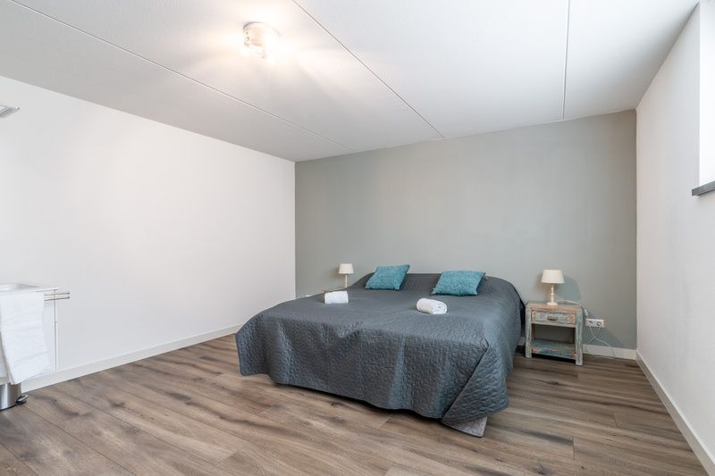 Komfortables Schlafzimmer in der Villa 106F, Bungalowpark 't Hoogelandt, Texel, mit grossem Bett und ruhiger Einrichtung.