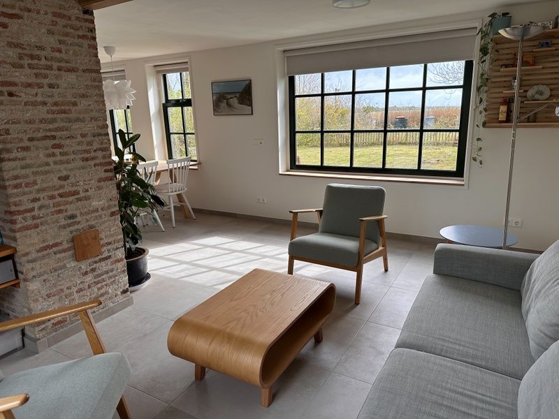 Helles Wohnzimmer in 't Seumerhuussie, Ferienhaus De Dennen Texel, mit moderner Einrichtung und Gartenblick.