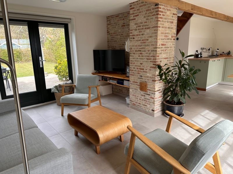Offenes Wohnzimmer und Kueche in 't Seumerhuussie, Ferienhaus De Dennen Texel, mit Zugang zur Terrasse.
