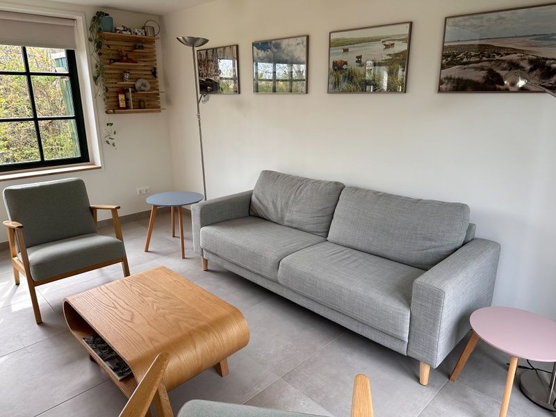 Moderne Sitzecke in 't Seumerhuussie, Ferienhaus De Dennen Texel, mit Kunst an der Wand und viel Licht.