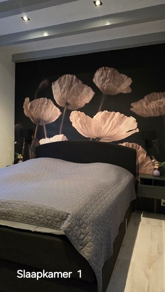 Attractive bedroom in Helianthus vacation home, De Dennen, Texel with floral wallpaper.