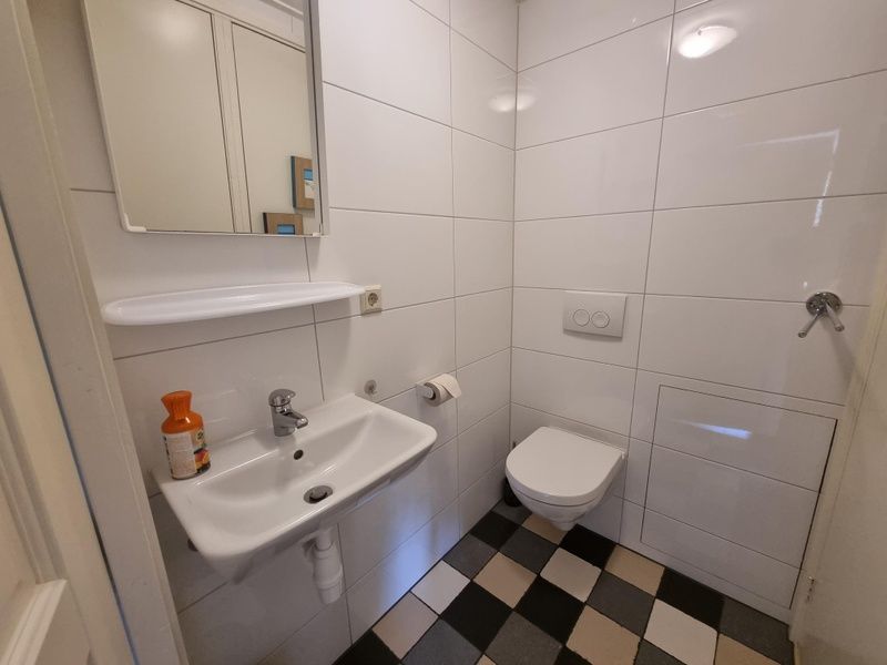 Moderne badkamer in Boszicht vakantiehuis in De Dennen, Texel met witte tegels.