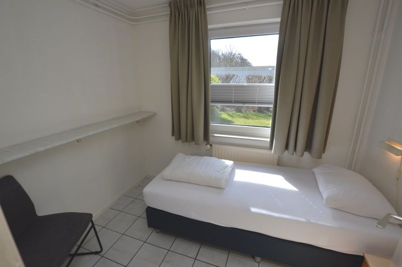 Helles Schlafzimmer im Ferienhaus Tempelierweg 37, De Dennen, Texel mit grossem Fenster und bequemem Bett.