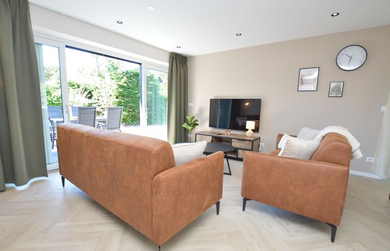 Helles Wohnzimmer mit Blick auf die Terrasse im Bungalow 't Hoogelandt 58, De Dennen Texel.