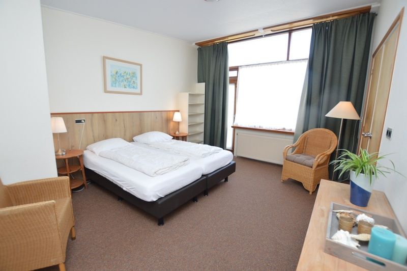 Geraeumiges Schlafzimmer im Ferienhaus Lelie, De Dennen, Texel mit bequemem Bett und natuerlichem Licht.