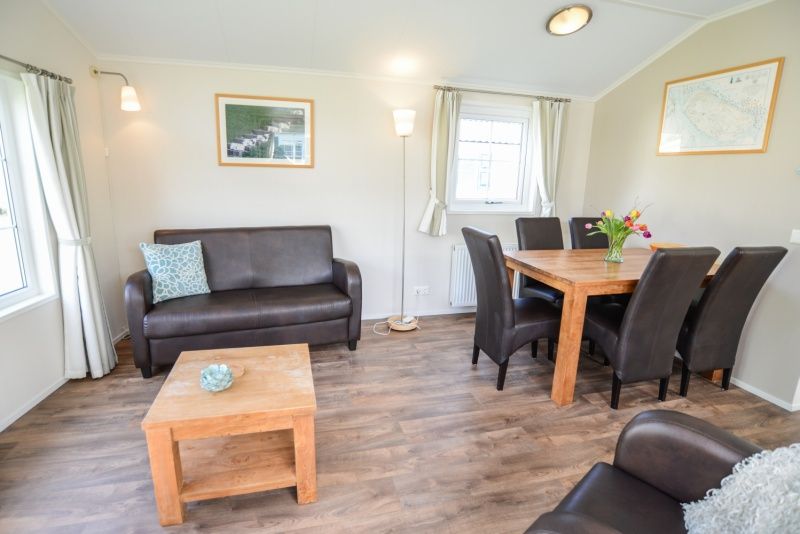 Stylish living room with wooden furniture in Holiday Park De Koorn-aar Type F, De Dennen, Texel.
