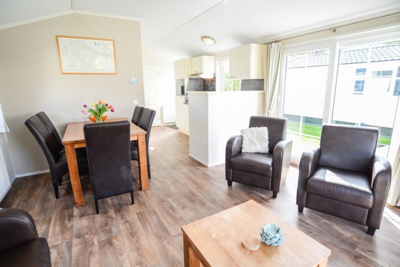 Spacious indoor room with dining and sitting area in Holiday Park De Koorn-aar Type F, Texel, Wadden Islands.