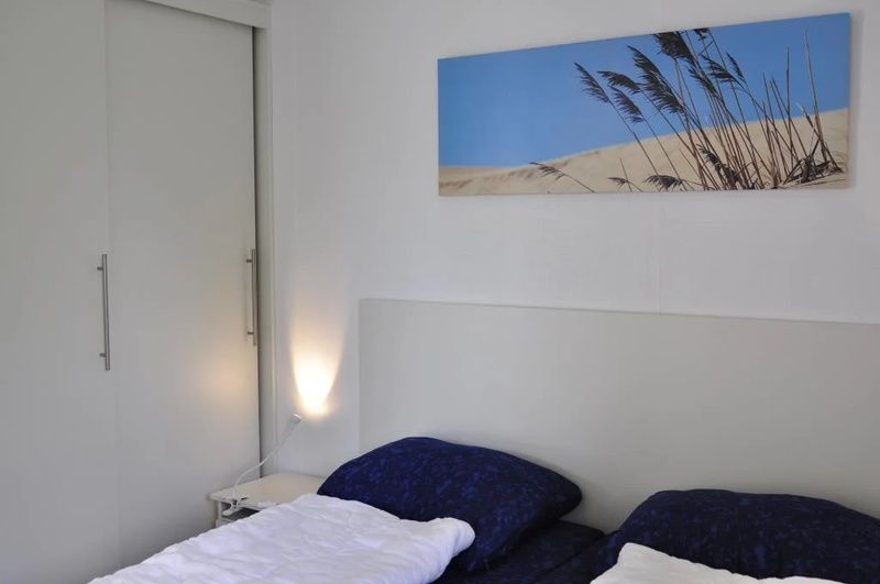 Comfortable bedroom in Holiday Park De Koorn-aar Type F, De Dennen, Texel, with art on the wall.