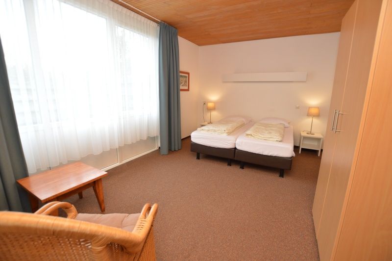 Schlafzimmer im Ferienhaus Iris, De Dennen, Texel mit bequemen Betten und natuerlichem Licht.