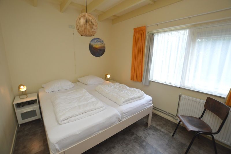 Sfeervolle slaapkamer in Tempelierweg 27 - Matranos, vakantiehuis in De Dennen, Texel met grote ramen.