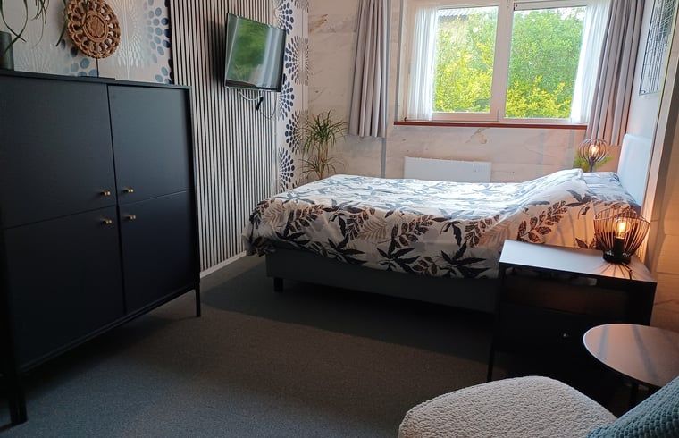 Comfortabele slaapkamer in Huisje in Oosterend, Terschelling met uitzicht op de tuin.