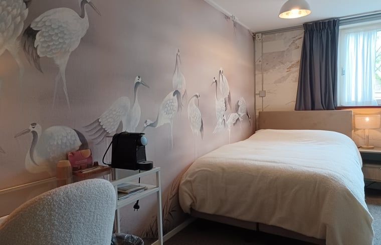 Slaapkamer met elegant vogelbehang in Huisje in Oosterend, Terschelling.