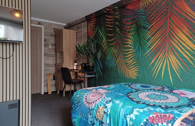 Slaapkamer met tropisch thema in vakantiehuis Oosterend, Waddeneilanden.