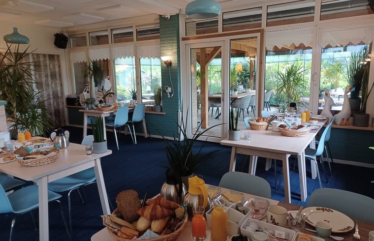 Ontbijtruimte met uitzicht op veranda in Huisje in Oosterend, Terschelling.