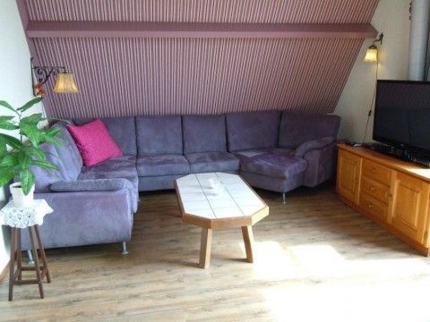 Gemtliches Wohnzimmer mit Ecksofa in der Wohnung Havenzicht, West-Terschelling, Watteninseln.