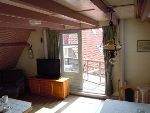 Helles Wohnzimmer mit Zugang zum Balkon in der Wohnung Havenzicht, West-Terschelling, Wadden Islands.