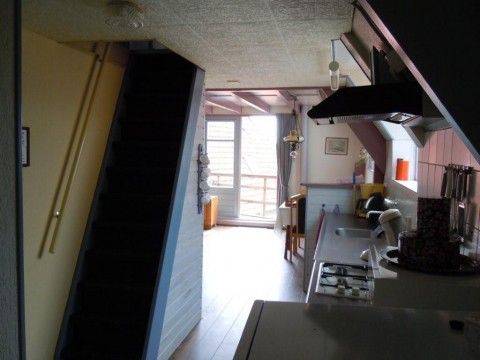 Eingangsbereich und Kche der Wohnung Havenzicht, West Terschelling, mit Treppe zum Obergeschoss.