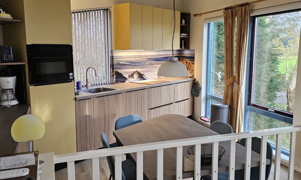 Sunny terrace at Glissando bungalow, Midsland Noord, Terschelling with parasol and garden table.